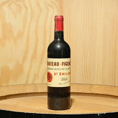 a bottle of wine sitting on top of a wooden barrel