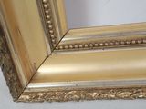 an image of a picture of a gold frame on a white wall