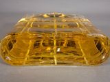 a yellow glass container with a lid on a table