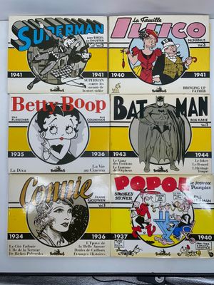 Plusieurs bandes dessinées sont exposées sur un mur dans une pièce