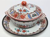 a bowl and plate with a lid on a white table