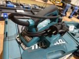 a corded sander sitting on top of a tool box