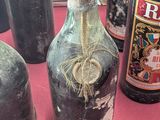 many bottles of wine on a table with a red cloth