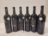 six bouteilles de vin sont alignées sur une table