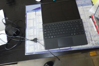 un ordinateur portable posé sur un bureau, à côté d'une souris et d'un clavier