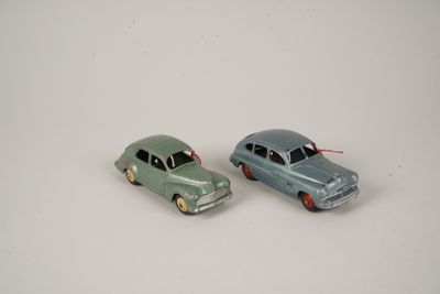 two toy cars sitting side by side on a white surface