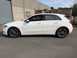 the white mercedes cla is parked in front of a building
