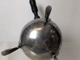 a small silver object on display on a clear surface