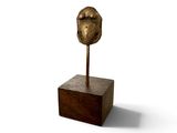 une sculpture représentant un oiseau sur un bloc de bois