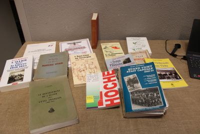 de nombreux livres posés sur une table sur laquelle se trouve un ordinateur portable