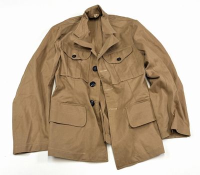 La veste est de couleur beige clair et comporte des boutons sur le devant.