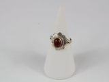 a close up of a ring with a red stone on it