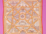 an orange and white square scarf with a picture of a city on it