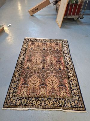 un tapis posé à même le sol dans une pièce où se trouvent une chaise et d'autres objets