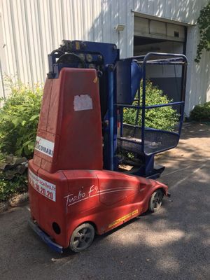 un chariot élévateur rouge garé devant un bâtiment