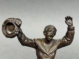 bronze figurine of a sailor holding a baseball glove and a ball