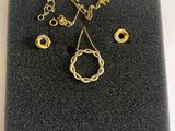 une photo d'un ensemble composé d'un collier et de boucles d'oreilles posé sur un morceau de tissu