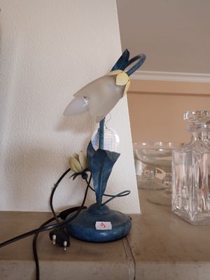 une lampe posée sur une table à côté d'un vase en verre