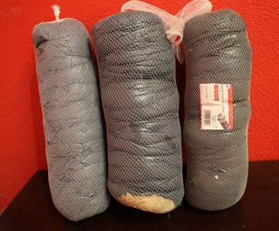 trois morceaux de tissu emballés dans un sac en filet, posés sur une table