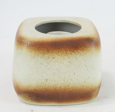 a brown and white vase on a white surface