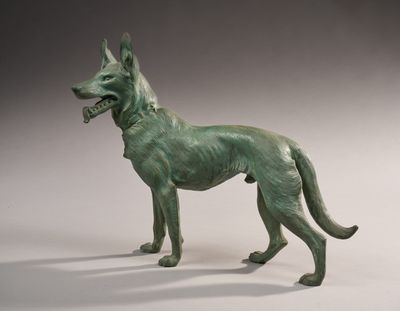 statue d'un chien portant un collier, sur fond blanc