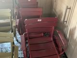 de nombreuses chaises rouges alignées dans un coin de la pièce