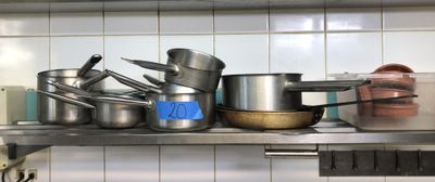 de nombreuses casseroles et poêles sur l'étagère de la cuisine