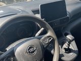 steering wheel and dashboard of a car in a parking lot with other cars in the background