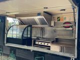 a food truck that has a grill on the side of it