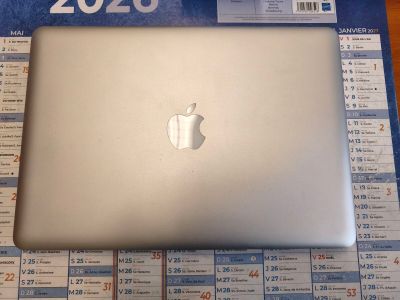 a silver apple laptop sitting on top of a table