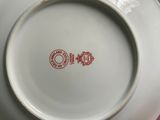 a white plate with a red design on it