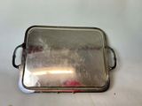 a silver tray with a handle on a white table