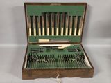 a wooden case with silverware in it on a white surface
