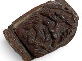 an old wooden bracelet with carvings on it on a white surface