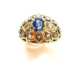 gros plan d'une bague avec une pierre bleue entourée de diamants