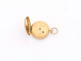 a close up of a gold pocket watch on a white surface