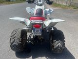a red and white atv parked on the side of the road
