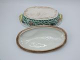 a white plate with a fish design on it and a bowl with a lid