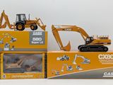 three toy excavators in boxes on a white surface