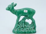 a small green deer figurine with a tag on it
