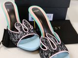 the black and pink shoes are next to a black box