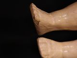 a close up of a doll ' s legs and feet on a black background