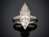 une bague en diamant blanc posée sur une surface noire