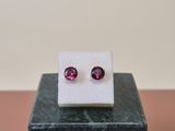 a pair of pink tourmaline earrings sitting on top of a marble block