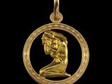 un gros plan d'un pendentif plaqué or représentant un homme à l'intérieur d'un cercle