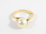 gros plan d'une bague en perle sur une surface blanche