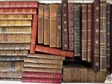 de nombreux livres anciens dans une boîte blanche posée sur une table