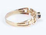 a close up of a gold ring with a black and white diamond