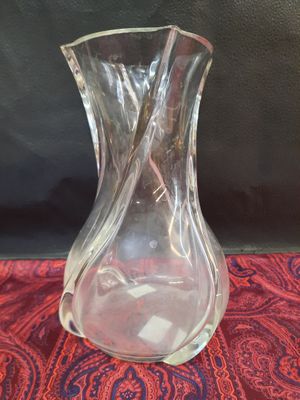 un vase en verre posé sur un tissu rouge