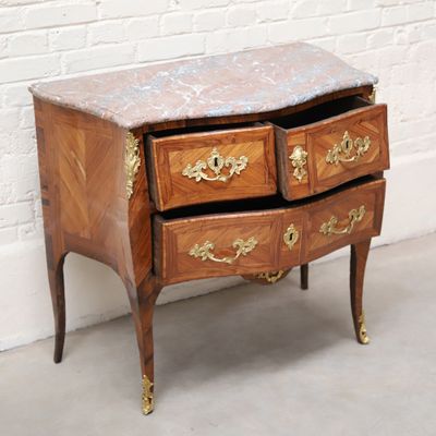 a marble top chest of drawers on a wooden stand
